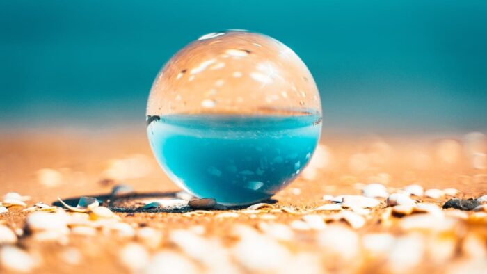 clear glass ball on brown sand during daytime