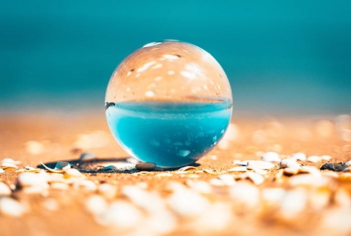 clear glass ball on brown sand during daytime