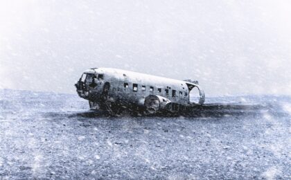 crashed airplane on sand grayscale photography